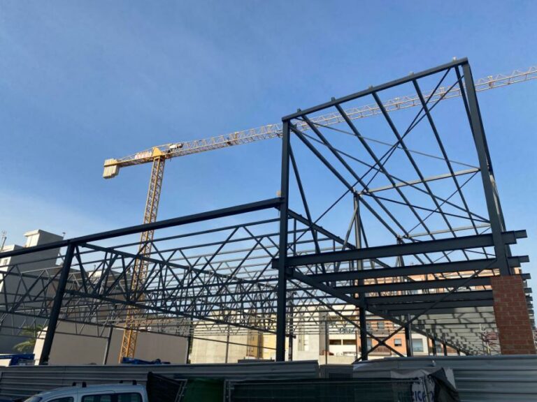 Montaje de estructura metálica industrial para nueva nave. Cerchas y vigas de acero de gran formato en construcción.