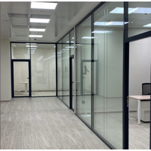 Instalación de mamparas divisorias de cristal con perfilería minimalista de aluminio negro en oficinas. Diseño interior de despachos modernos con cristales de seguridad.
